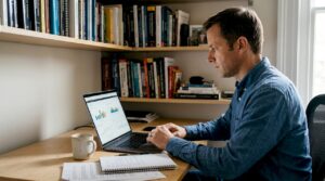 Homem acompanhando gráficos de investimentos no computador em casa